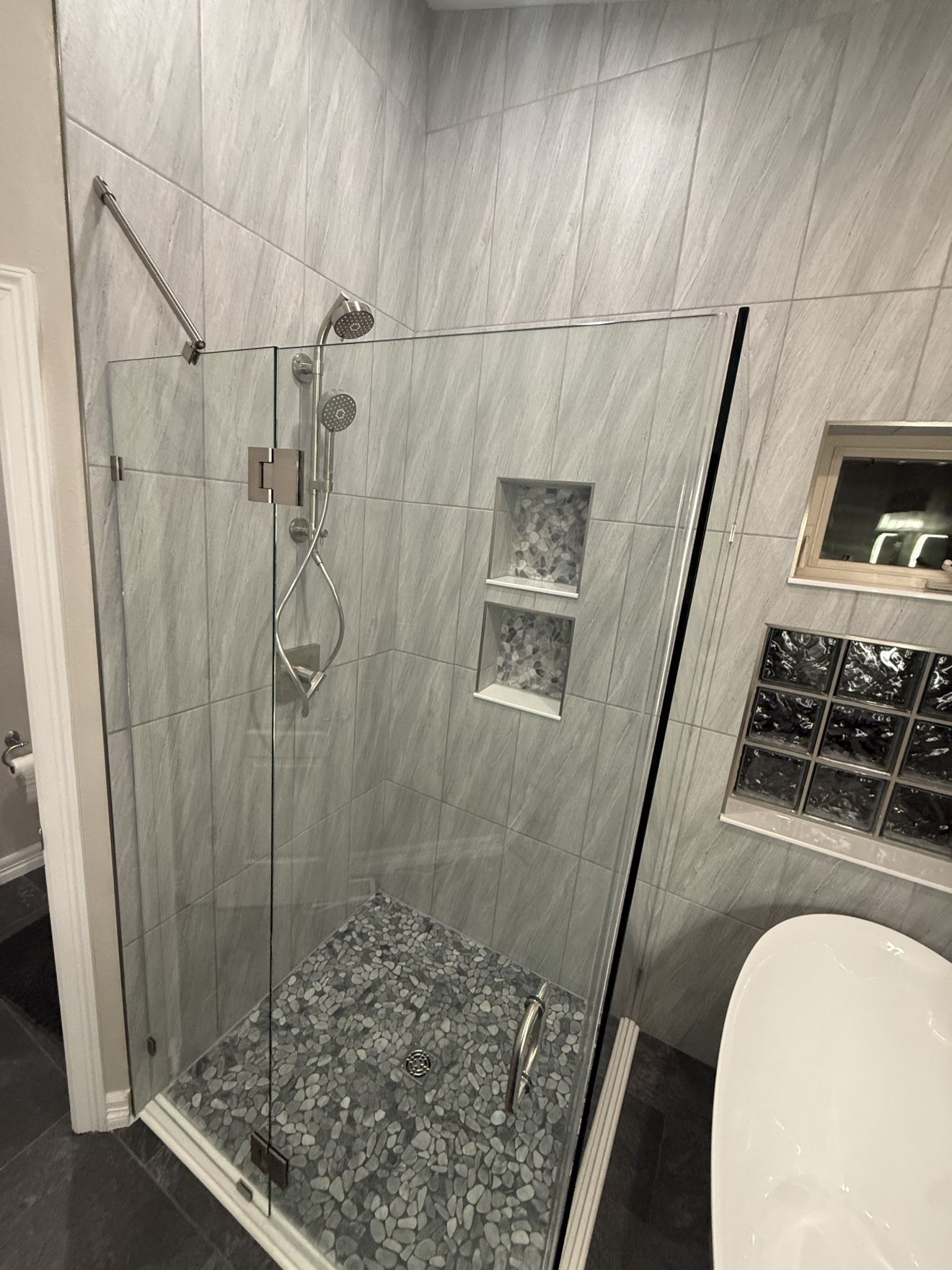 Pebble tile shower floor in the finished bathroom
