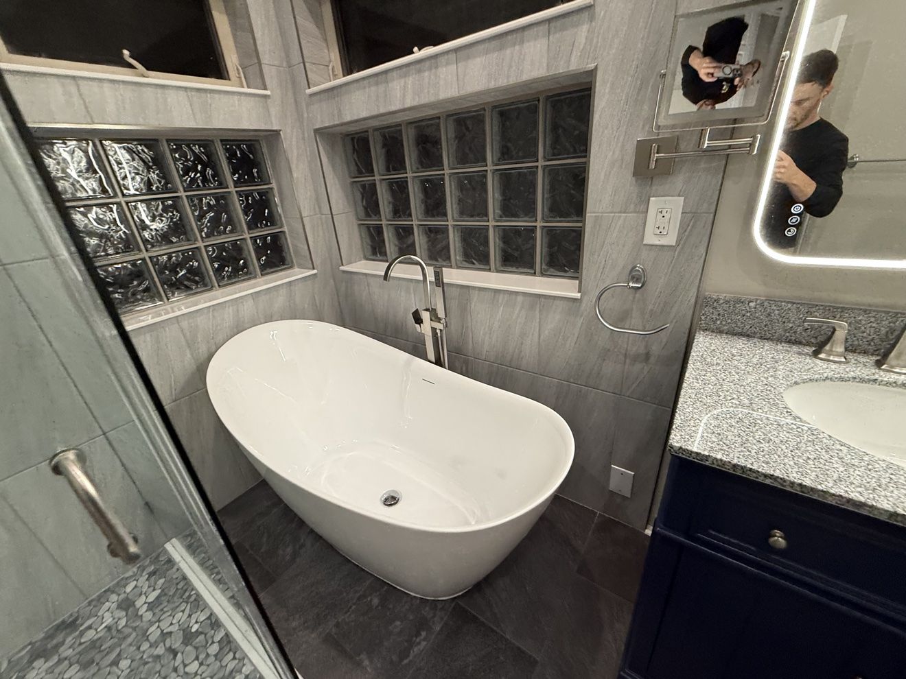 Freestanding soaking tub with floor-mounted filler in a remodeled primary bathroom