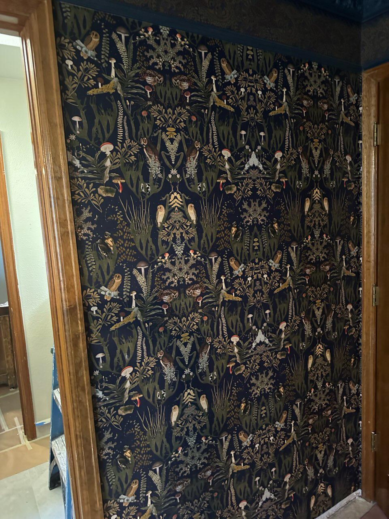 Dark botanical wallpaper installation, close-up detail
